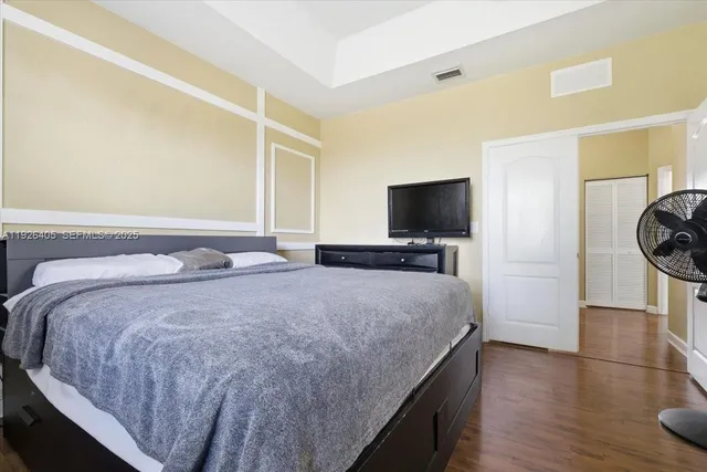 a bedroom with a bed and wooden floor