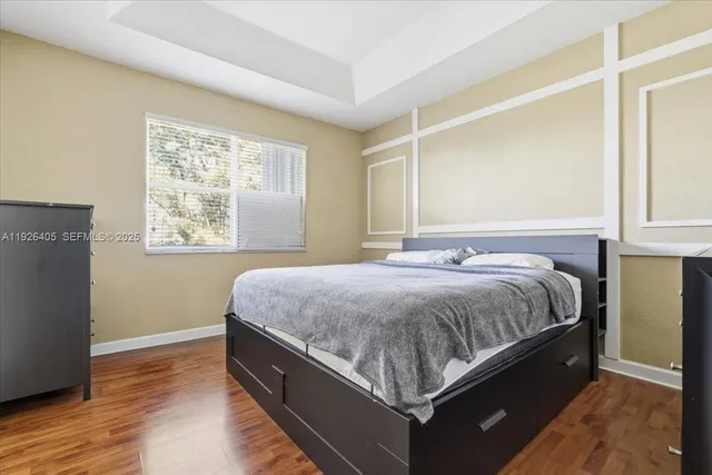 a spacious bedroom with a bed and wooden floor
