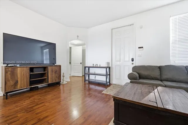 a living room with furniture and wooden floor