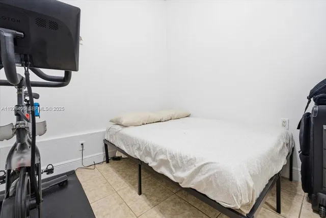 a bedroom with a bed and a flat tv screen on the table