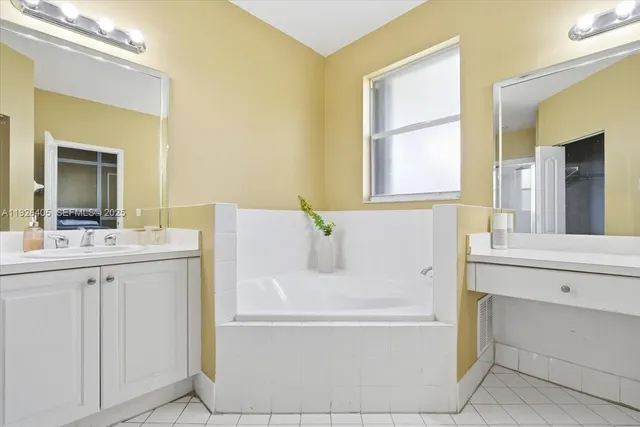 a bathroom with a tub sink and mirror