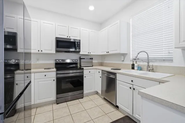 a kitchen with cabinets stainless steel appliances and a sink