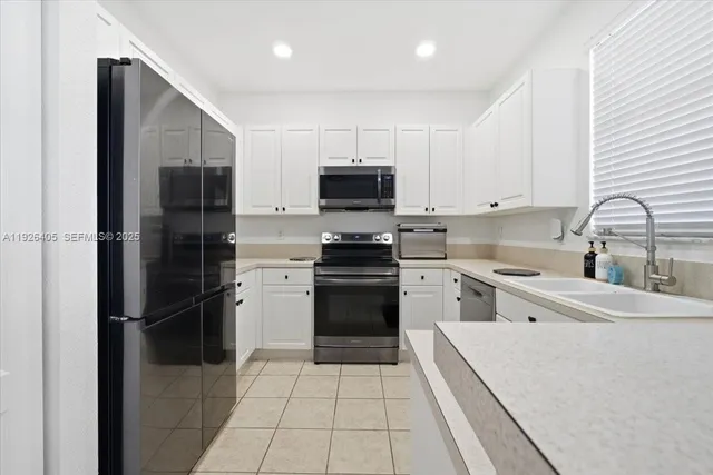 a kitchen with a refrigerator and a stove top oven