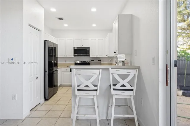 a kitchen with stainless steel appliances a stove a sink and a refrigerator