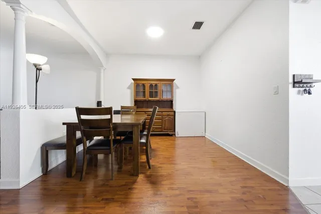 a view of a a dining room with furniture window and wooden floor
