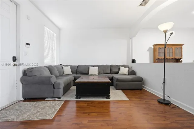 a living room with furniture and a wooden floor