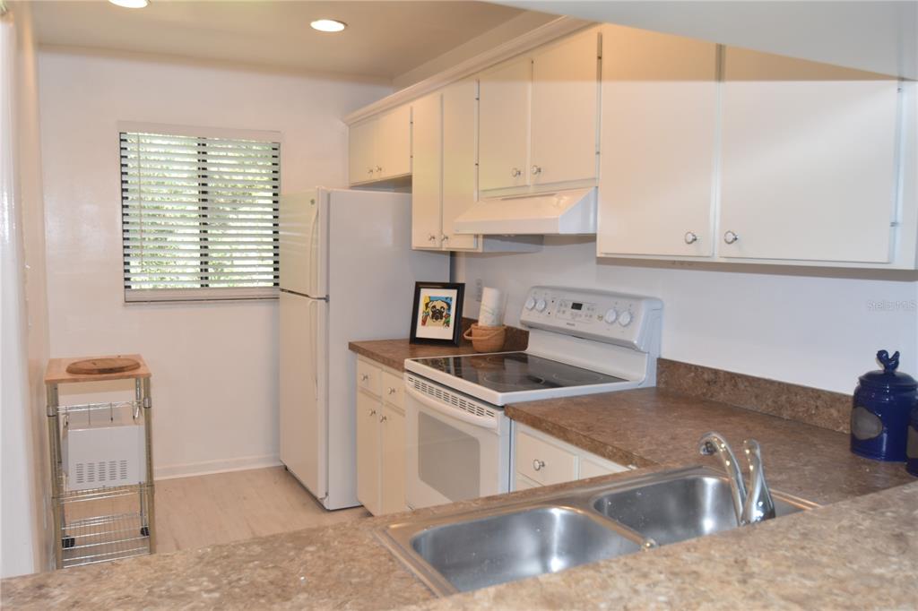 1709 Pelican Cove Road, Unit GL446 Sarasota, FL 34231 - Photo 14 of 25 a kitchen with stainless steel appliances granite countertop a sink a stove and a microwave