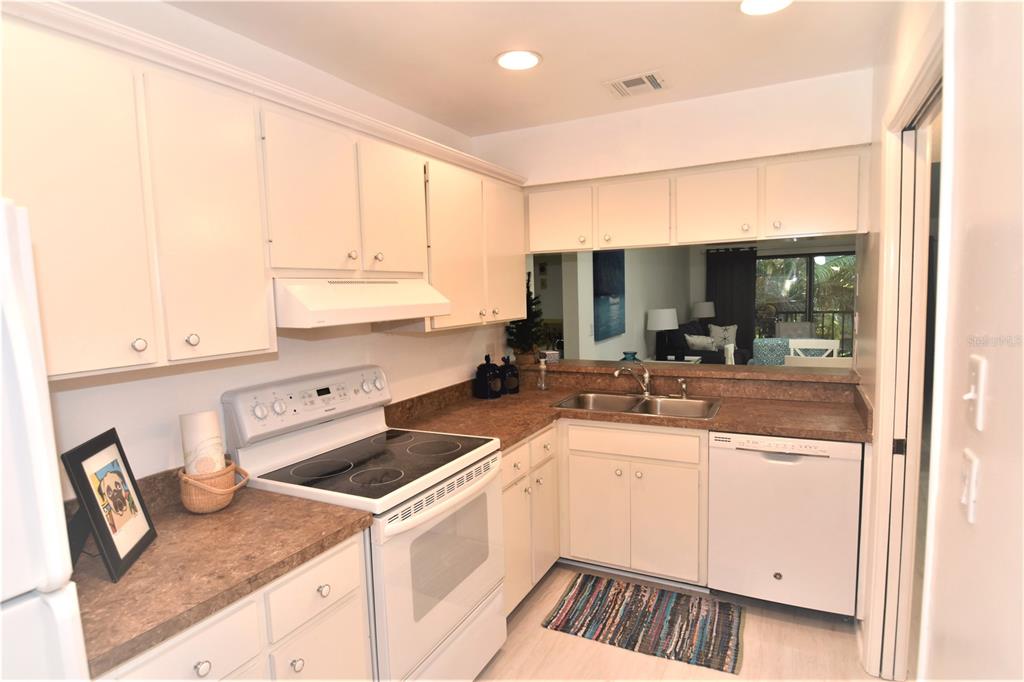 1709 Pelican Cove Road, Unit GL446 Sarasota, FL 34231 - Photo 2 of 25 a kitchen with a sink cabinets and window