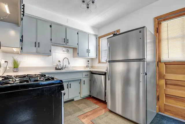 a kitchen with stainless steel appliances granite countertop a refrigerator stove and sink