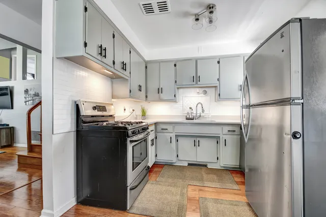 a kitchen with stainless steel appliances granite countertop a refrigerator a stove and a sink