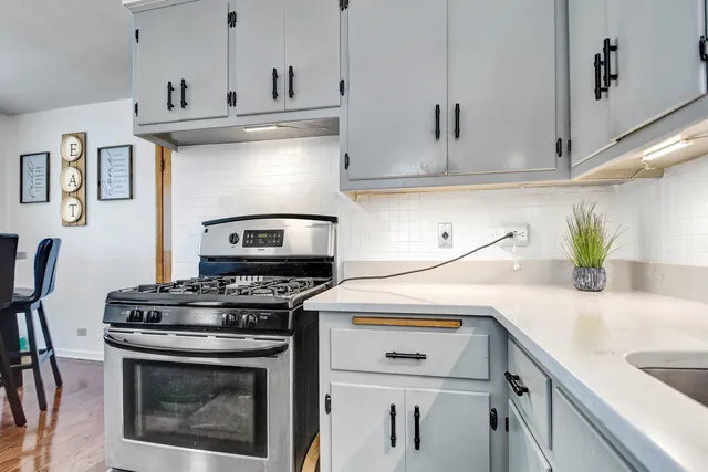 a kitchen with a stove and white cabinets
