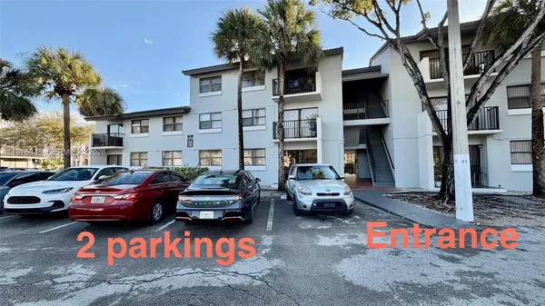a couple of cars parked in front of a house