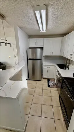 a kitchen with a sink a stove and a refrigerator