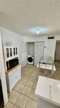 a kitchen with granite countertop a sink a stove and cabinets