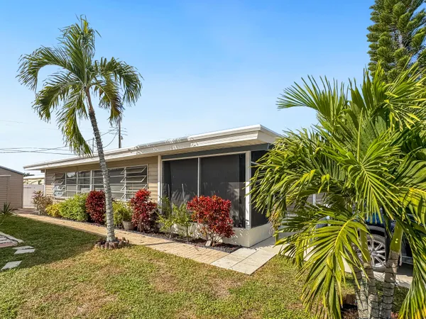 a front view of house with yard and trees around