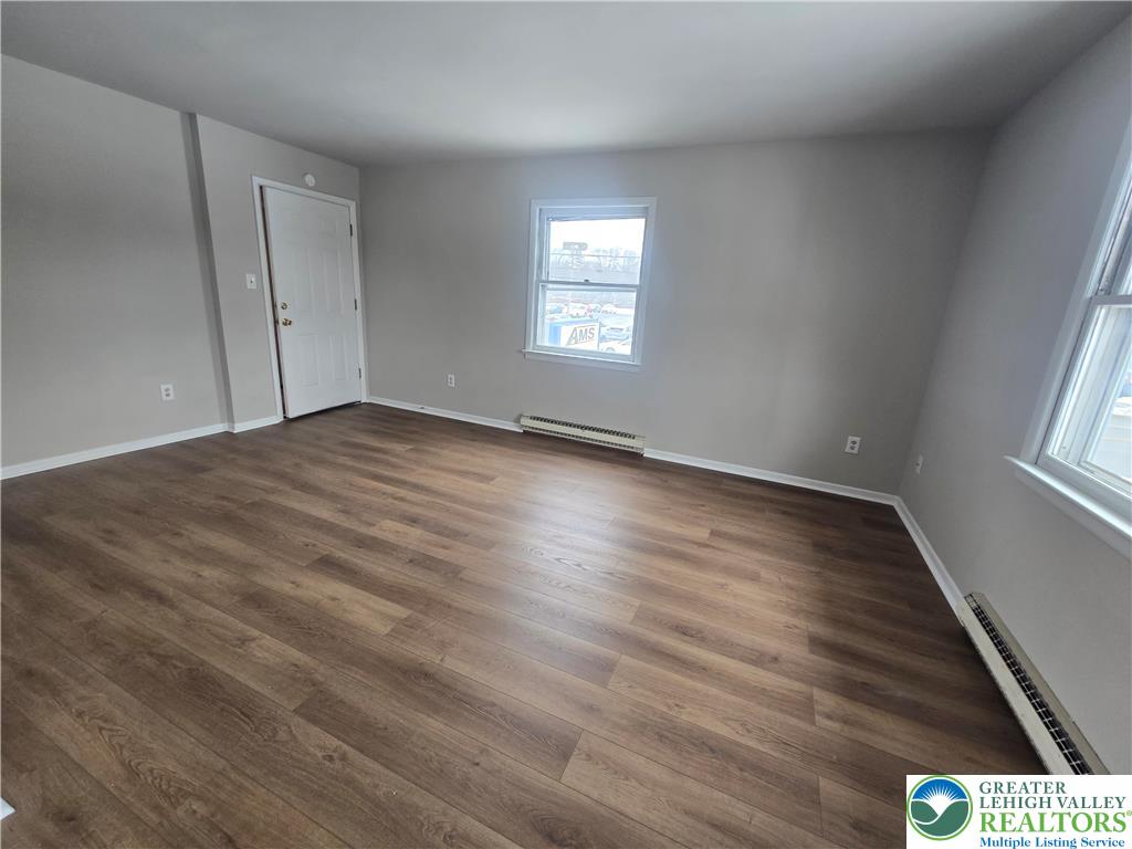 188 Jefferson Street, Unit 2 Emmaus, PA 18049 - Photo 3 of 9 an empty room with wooden floor and windows
