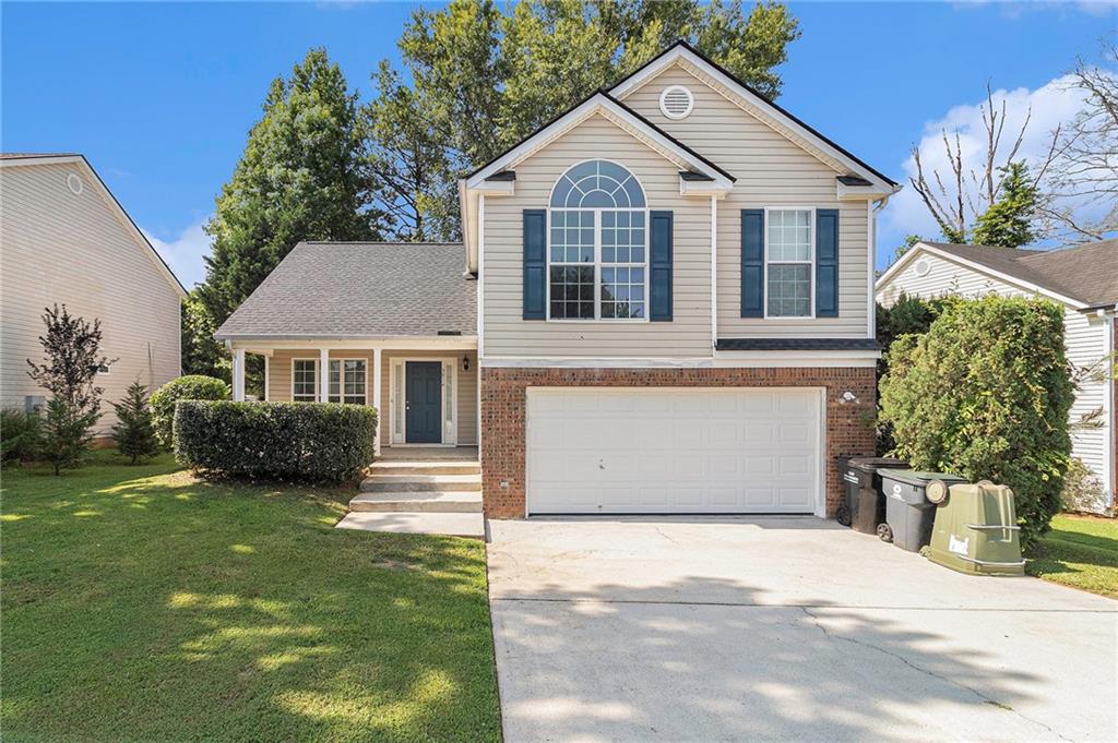 a front view of a house with a garden and plants