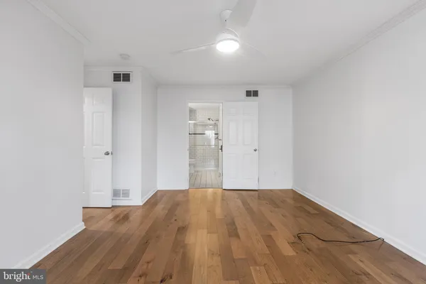 a view of a room with wooden floor and white walls