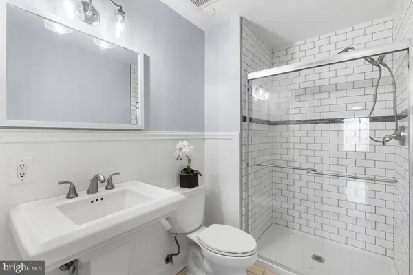 a bathroom with a sink a toilet and shower