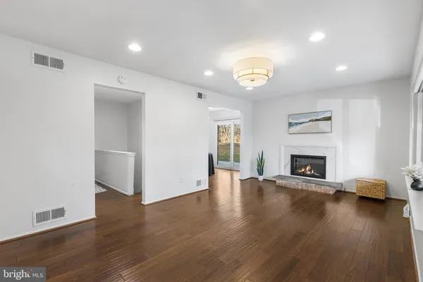 an empty room with wooden floor a fireplace and window