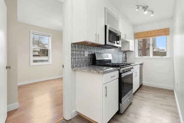 a kitchen with granite countertop a stove top oven and sink