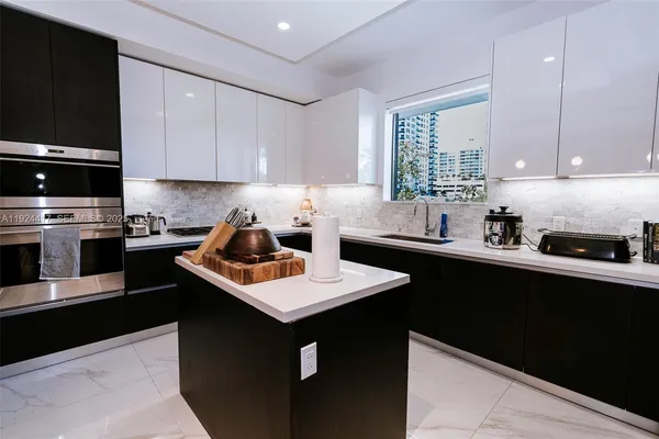 a kitchen with sink a microwave a refrigerator and cabinets