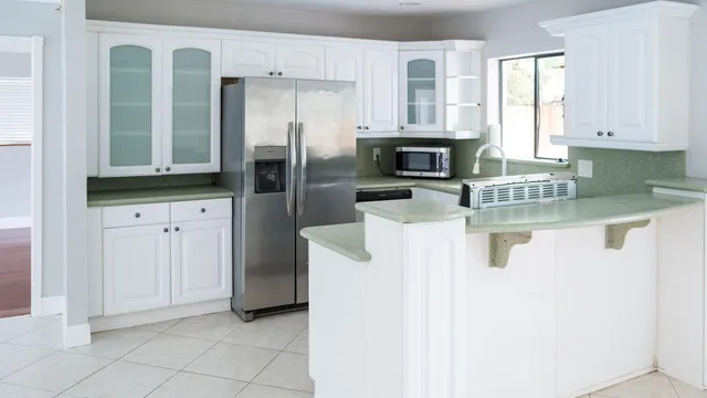 a kitchen with granite countertop a refrigerator a sink and a stove