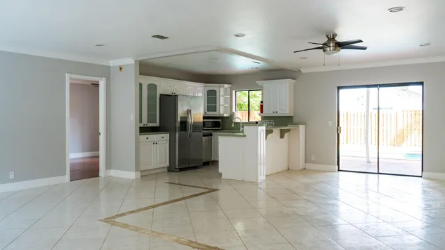 a kitchen with stainless steel appliances kitchen island granite countertop a refrigerator and a sink