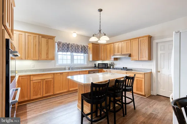 a kitchen with granite countertop wooden floors and white cabinets