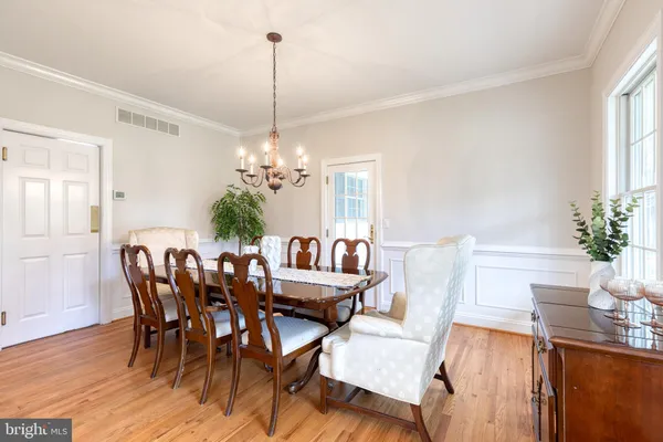 a view of a dining room with furniture wooden floor and chandelier