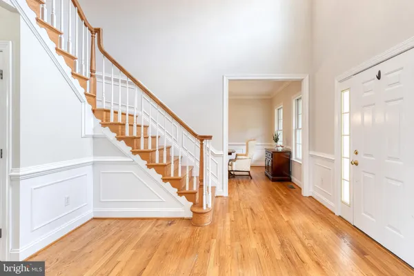 a view of a hallway with wooden floor and staircase