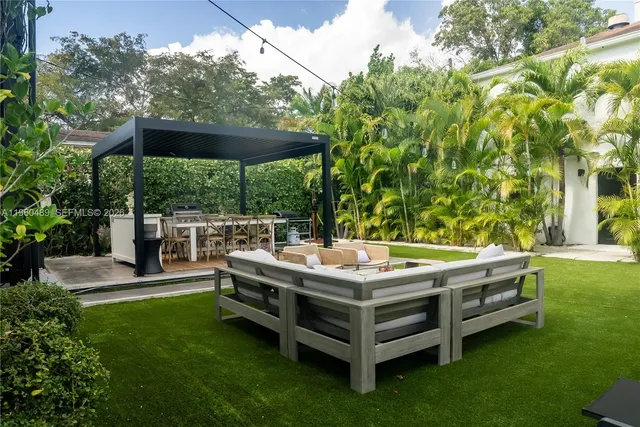 a view of a patio with a table and chairs under an umbrella