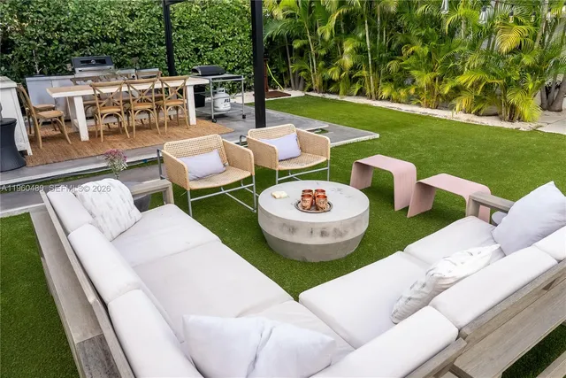 a view of a patio with table and chairs couches plants and large tree