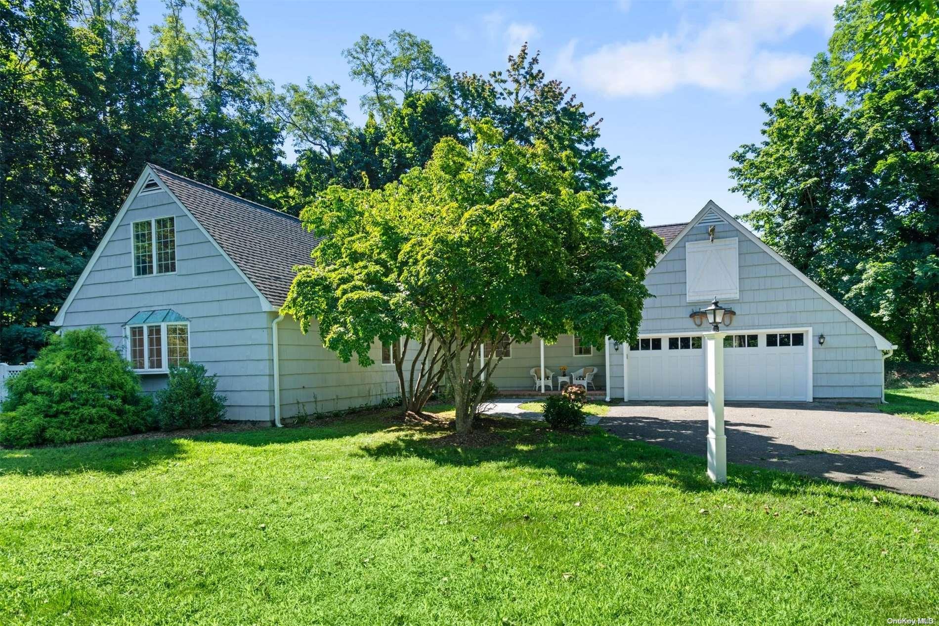 a backyard of a house with plants and large tree