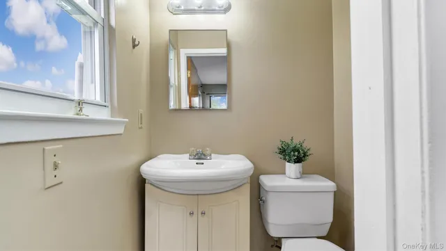 a bathroom with a sink toilet and a mirror