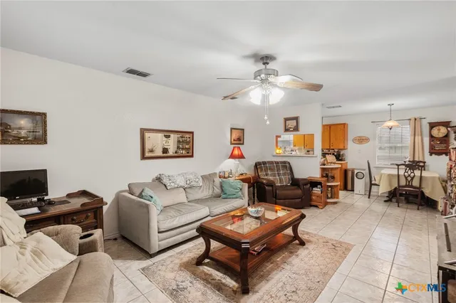 a living room with furniture a flat screen tv and a table