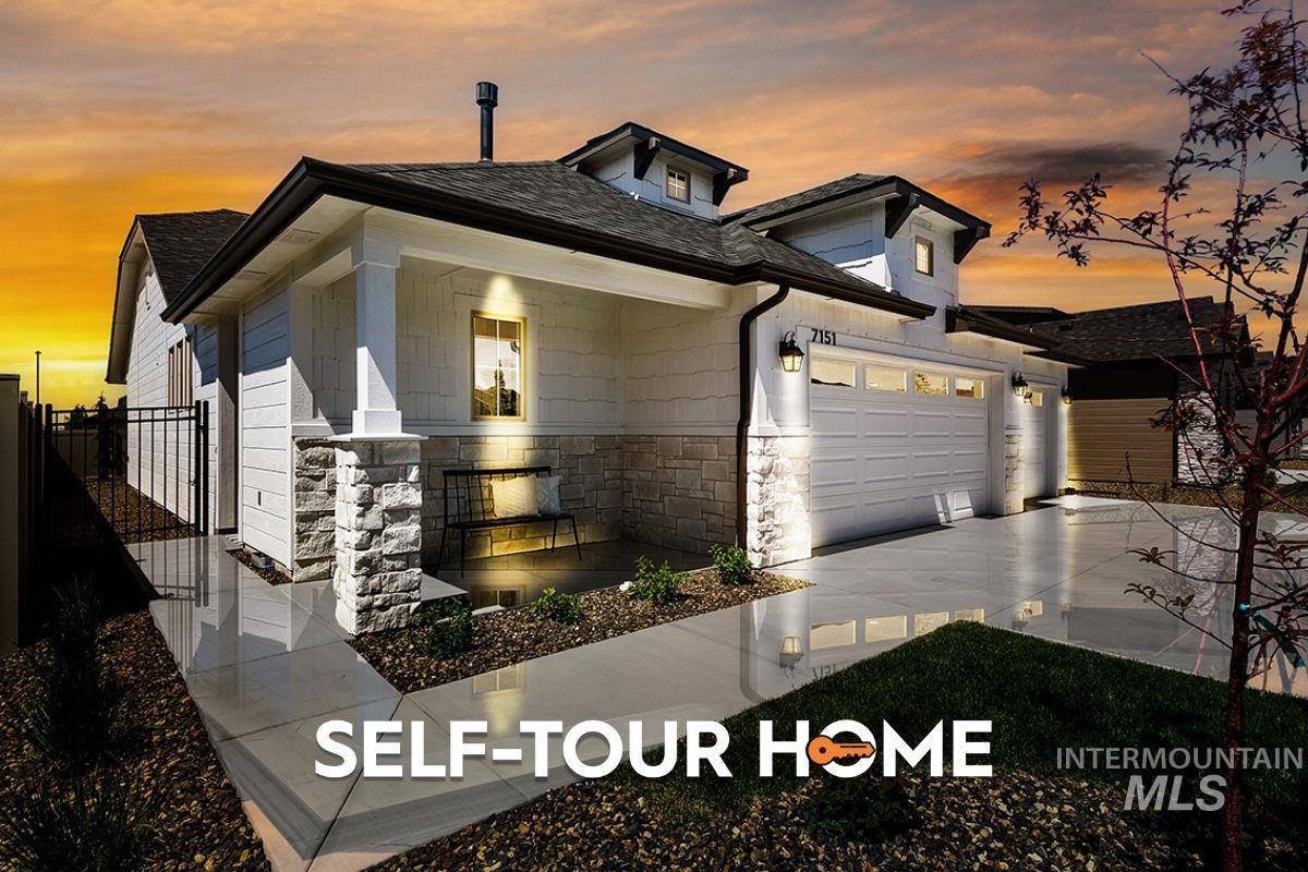 7151 South Skybreak Lane Meridian, ID 83642 - Photo 1 of 26 Contemporary residence featuring a covered front porch with stone accents, a multi-car garage with paneling, a concrete driveway, and a gated side entrance
