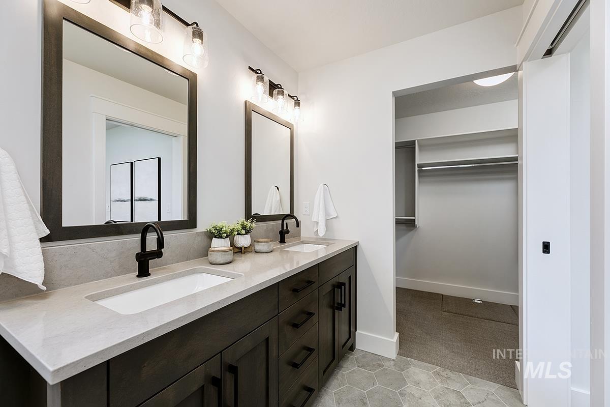 7151 South Skybreak Lane Meridian, ID 83642 - Photo 13 of 26 Dual vanity featuring dark wood-finish cabinetry and light-toned countertops