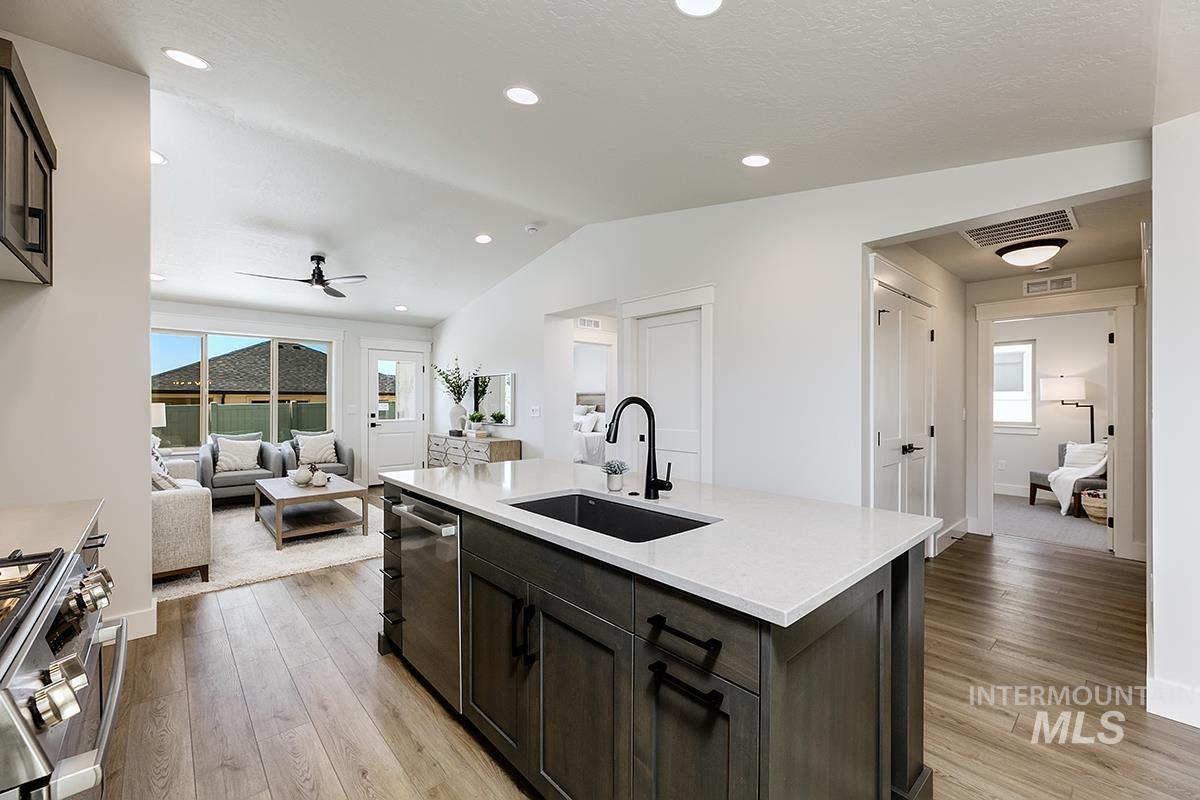 7151 South Skybreak Lane Meridian, ID 83642 - Photo 7 of 26 Spacious kitchen island featuring a white countertop, undermount sink with a matte black faucet, and integrated dishwasher
