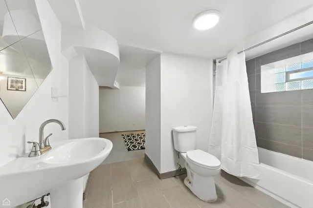 a bathroom with a toilet sink and a mirror