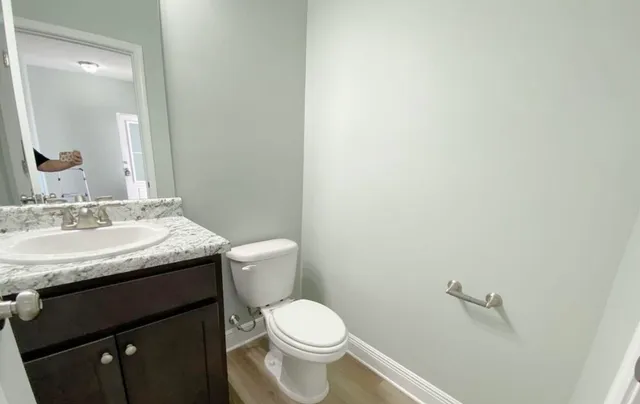 a bathroom with a granite countertop toilet and sink