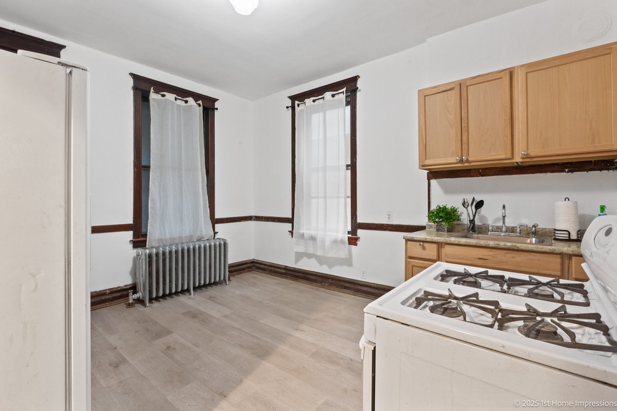 1833 South Troy Street Chicago, IL 60623 - Photo 7 of 18 a kitchen with stainless steel appliances granite countertop a stove a sink and a refrigerator
