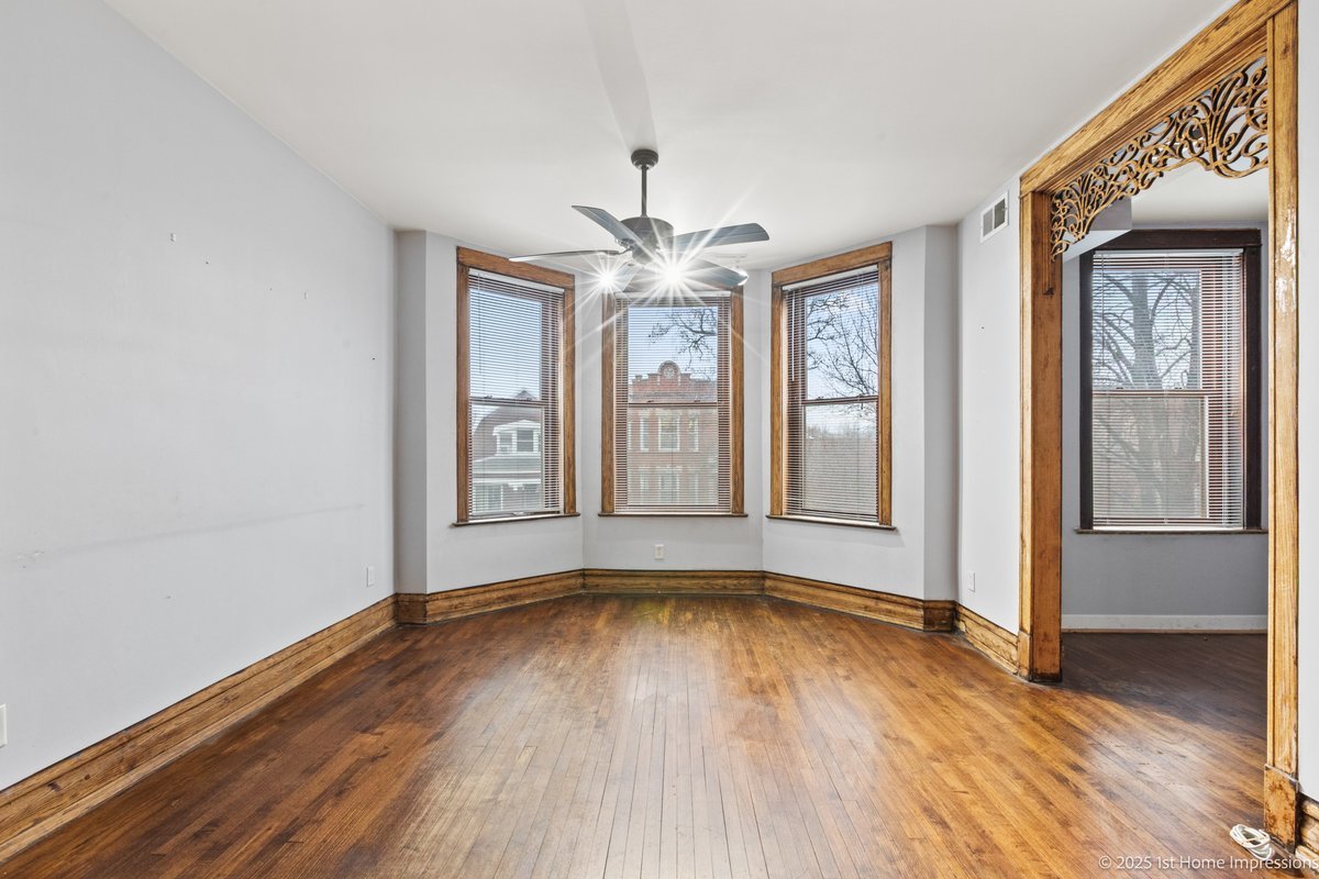 1833 South Troy Street Chicago, IL 60623 - Photo 9 of 18 a view of an empty room with wooden floor and a window