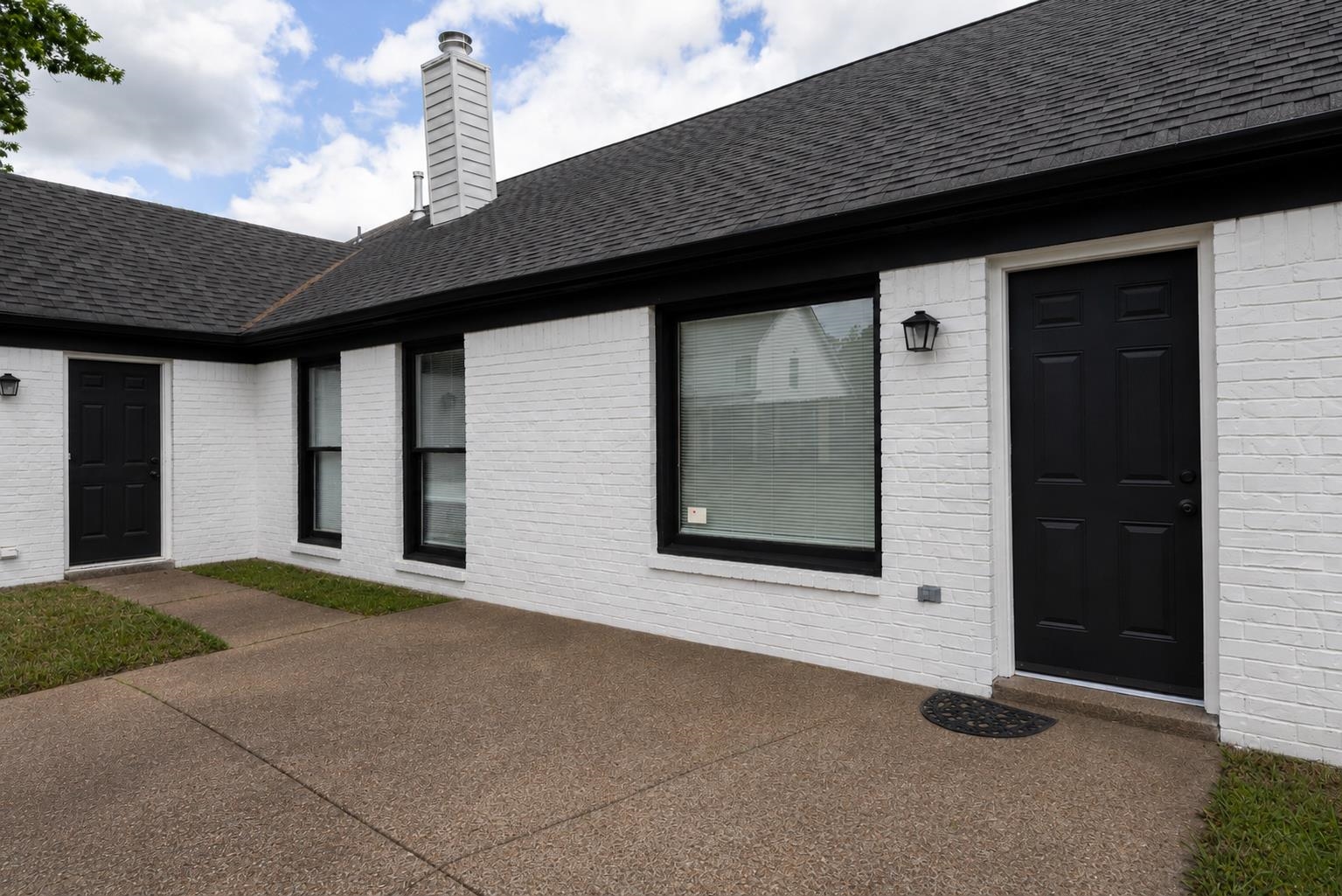 7421 Richmond Road Memphis, TN 38125 - Photo 38 of 39 White brick exterior with a dark shingle roof and black trim