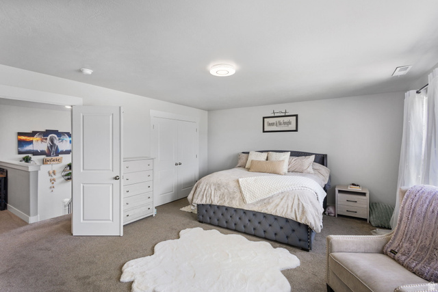 7889 Bristlecone Road Eagle Mountain, UT 84005 - Photo 22 of 42 Carpeted bedroom featuring white walls, a built-in closet with double doors, and an overhead flush-mount light fixture