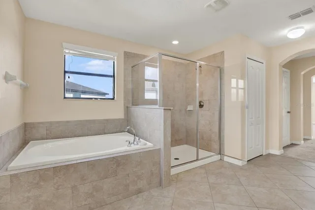 a bedroom with a large bed and a chandelier