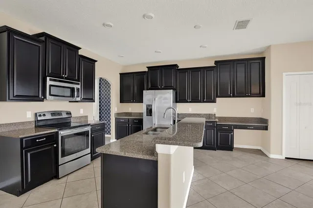 a kitchen with granite countertop stainless steel appliances and wooden cabinets