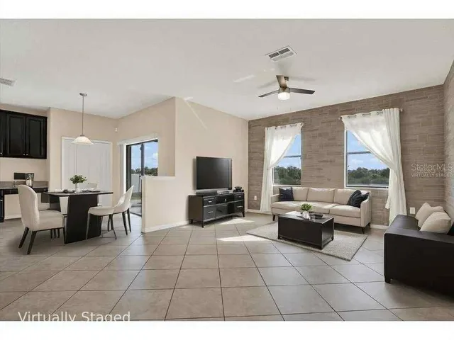a living room with furniture a flat screen tv and a large window
