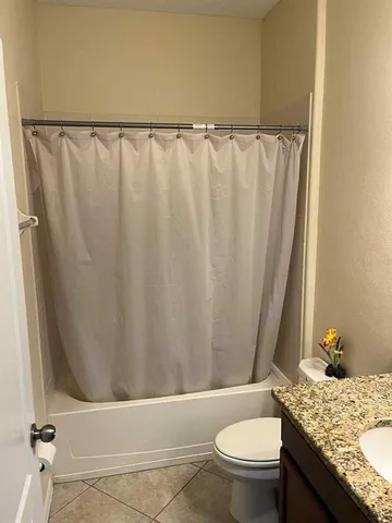 a bathroom with a granite countertop sink and toilet