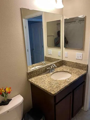 a bathroom with a granite countertop sink and a mirror